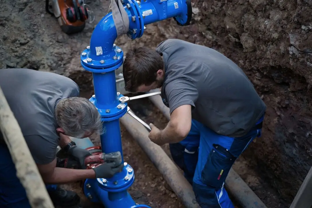 Mechaniker bei der Arbeit – Techniker bei der Rohrleitungsmontage, dokumentiert von einem Fotografen und Filmemacher für Handwerksbetriebe.